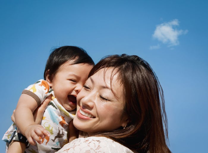 A mother hugging her second kid and smiling
