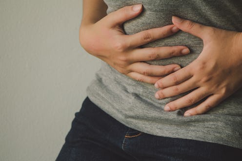 A person holding their stomach as they experience Adenomyosis