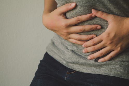 A person holding their stomach as they experience Adenomyosis 