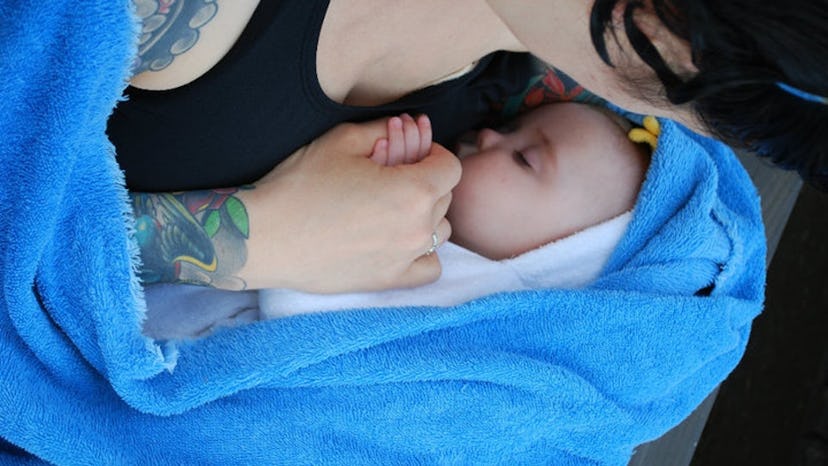 A tattooed mom holding her baby 