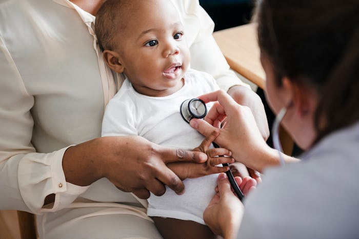 a baby on his mom's lap at the pediatrician