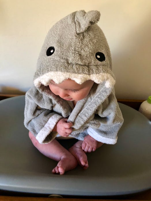 A 6-month-old in a robe in the shape of a shark