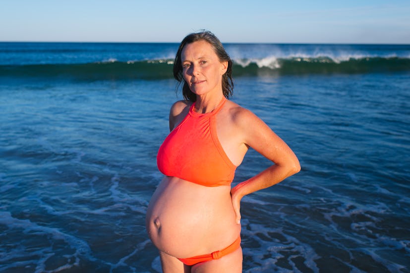 A pregnant woman posing at the seaside