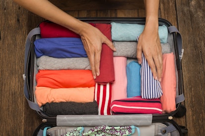 A suitcase packed with rolled clothes