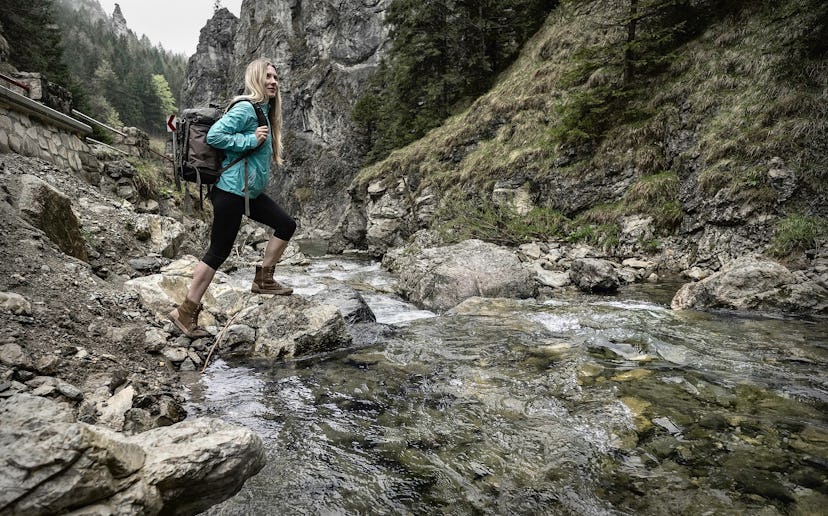 A female hiker passing a river