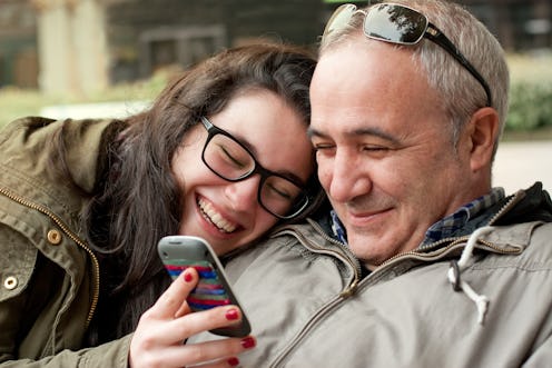 A father and daughter scrolling through instagram laughing at dad jokes