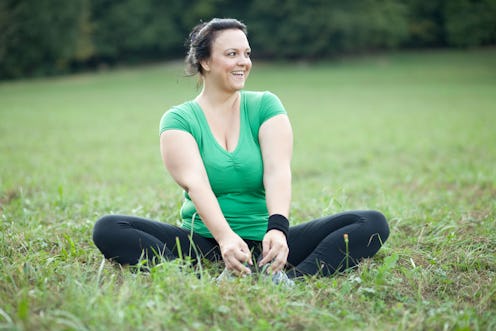 A woman sitting in a Turkish sitting pose in the nature, showcasing how to manage asthma as a woman