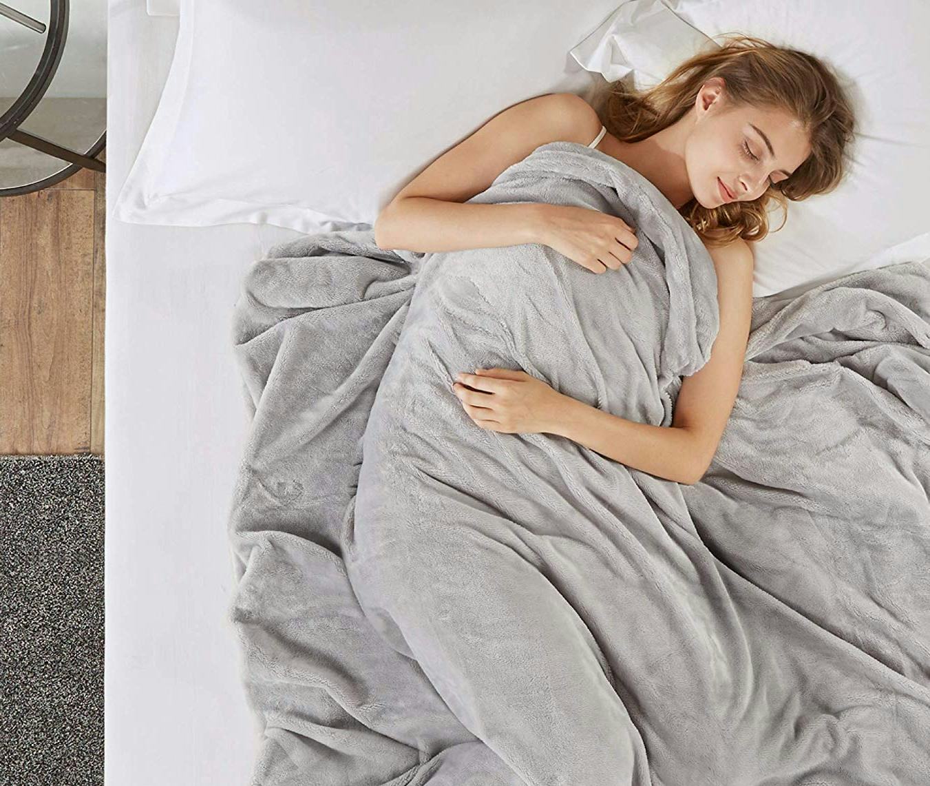 A woman sleeping in bed covered with a blanket