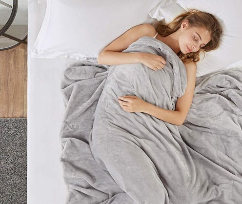 A woman sleeping in bed covered with a blanket