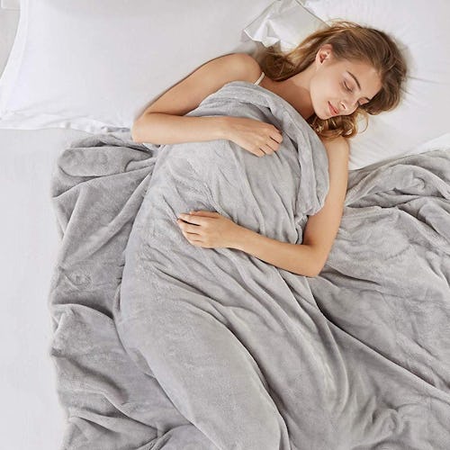 A woman sleeping in bed covered with a blanket