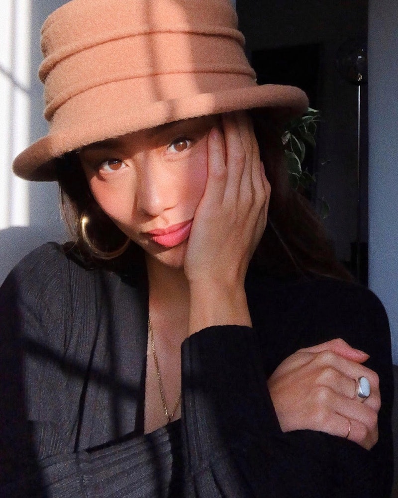 Los Angeles-based influencer Jenny Ong wearing a camel hat and a black top while posing for a photo.