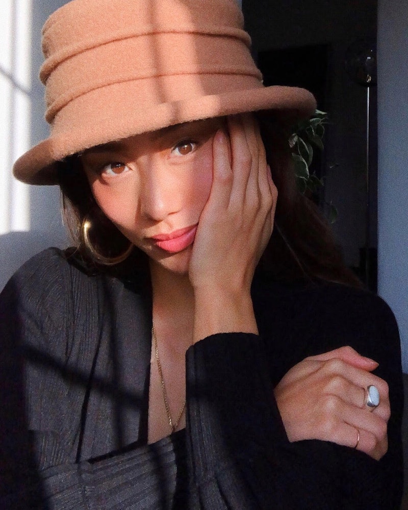 Los Angeles-based influencer Jenny Ong wearing a camel hat and a black top while posing for a photo.