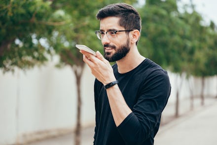 A young man talking to Siri on his phone