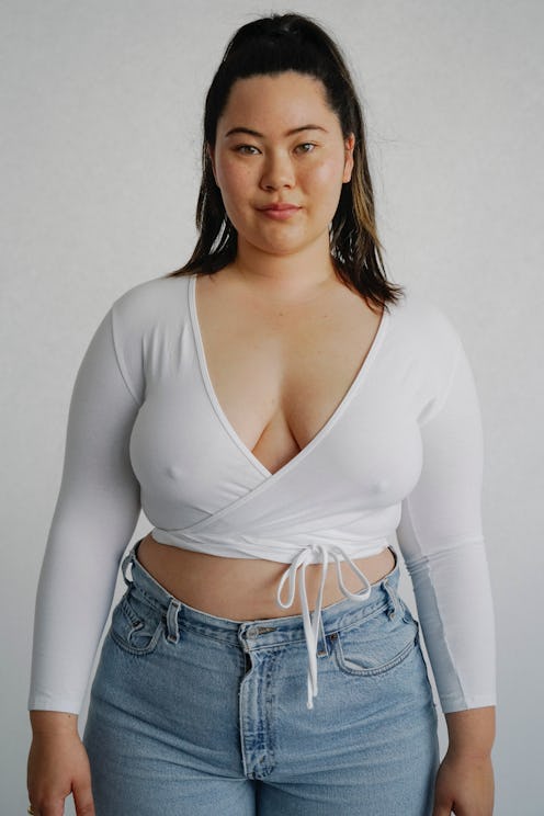 Plus size model Minami Gessel in pair of jeans and a white shirt.