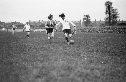  A black and white vintage photo of Lily Parr playing football.