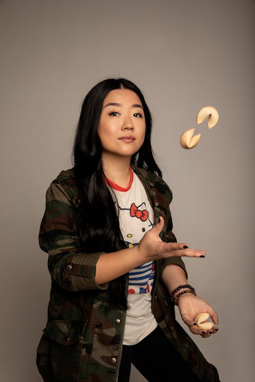 Sherry Cola posing in a camo shirt while juggling fortune cookies