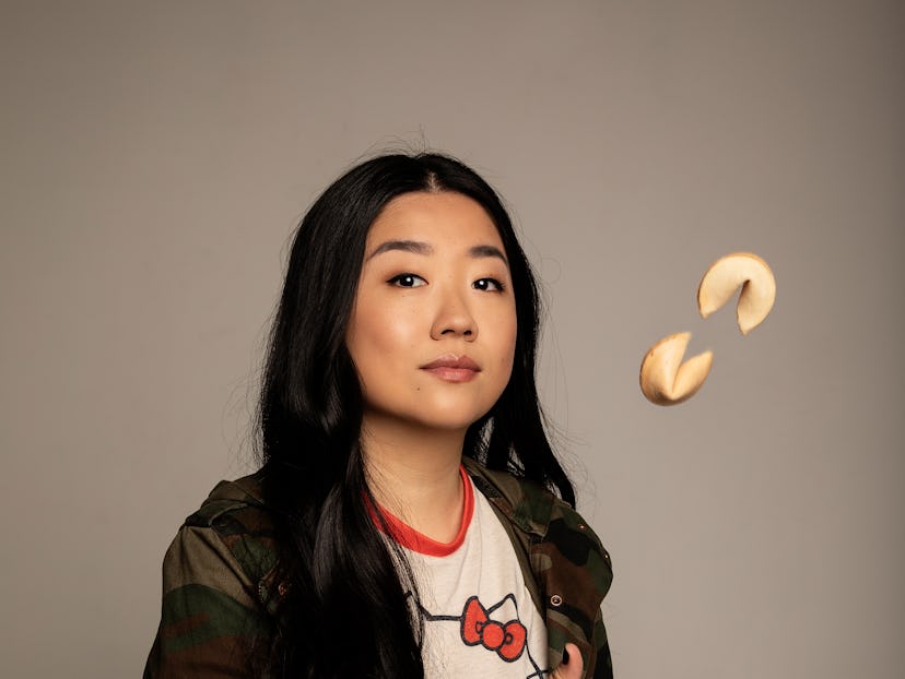 Sherry Cola posing in a camo shirt while juggling fortune cookies