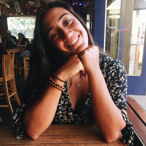  Isabel Thottam, a biracial Indian American, smiling for a photo in a coffee shop