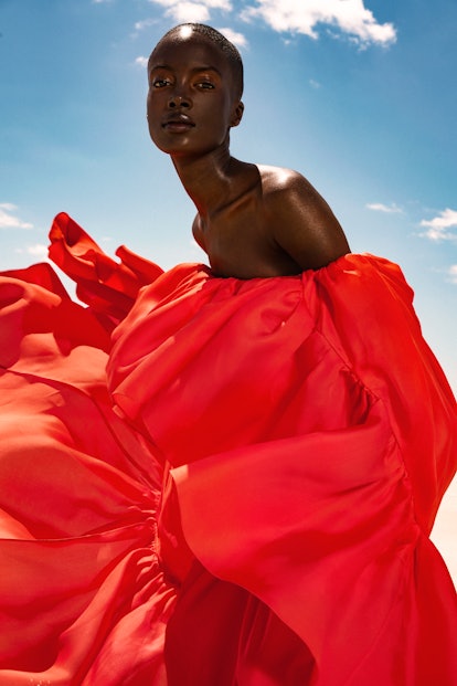 A model posing in an off-the-shoulder Carolina Herrera dress
