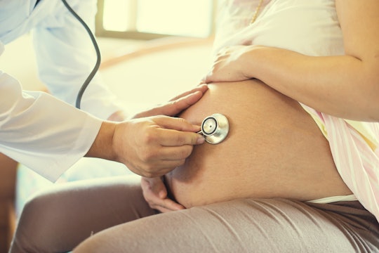 A pregnant woman getting checked by a doctor