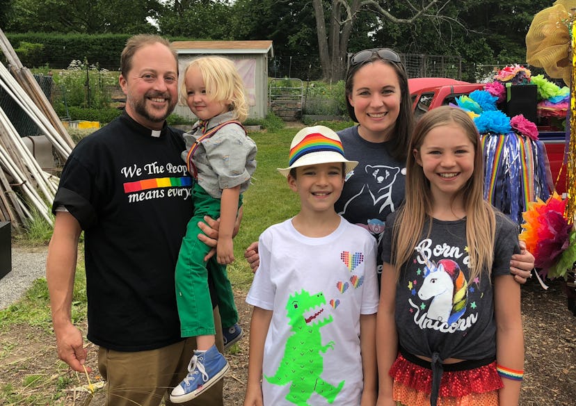 Parents posing with their three kids while wearing pride-themed shirts