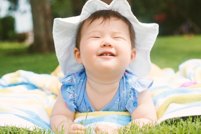 baby girl on lawn, smiling 