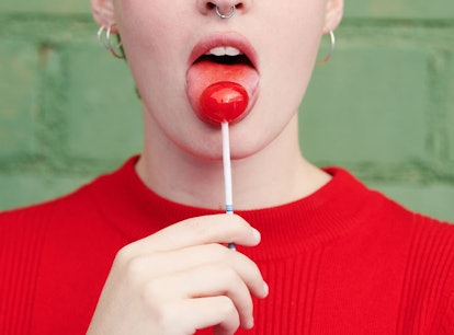 Woman with lollipop mimics what receiving oral sex feels like. 