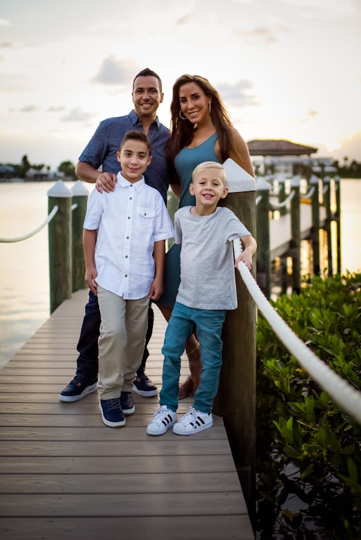Howie posing for a photo with his wife and two sons