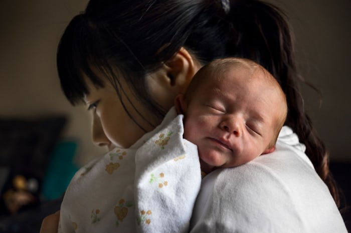 A new mom struggling with health anxiety holding her sleeping baby