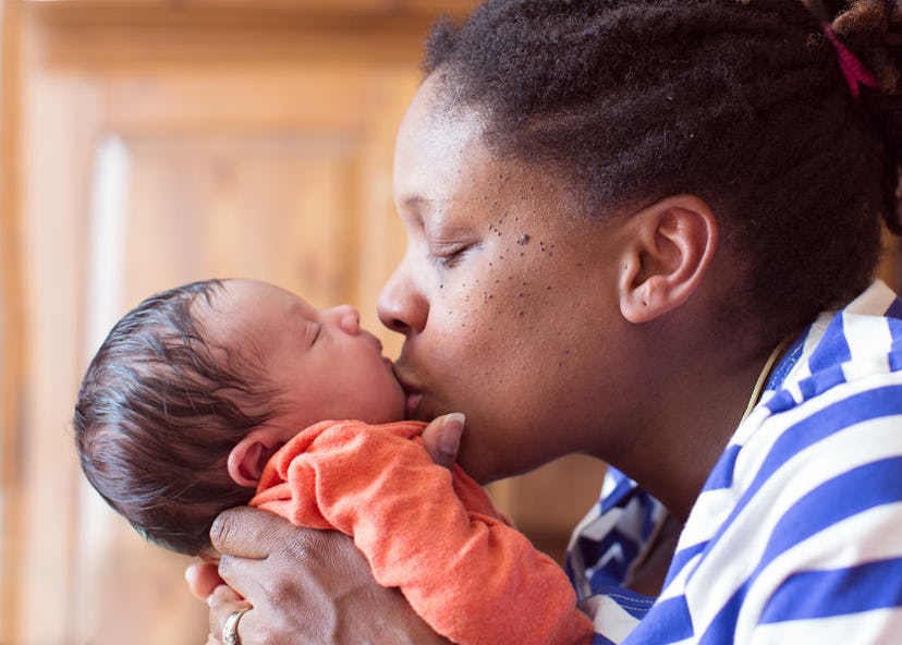 A new mom struggling with health anxiety kissing her baby