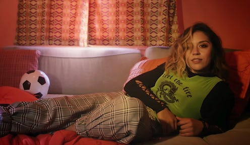 Chelcee Grimes, a world-class footballer and a successful musician, lying on a couch with a soccer b...