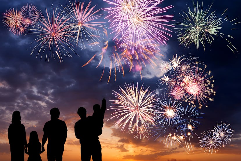 Silhouettes of a family watching the Fourth of July fireworks