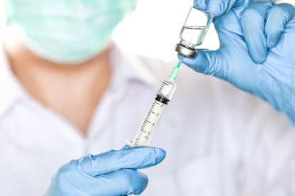 A doctor taking Gardasil out its small tube in a vaccine