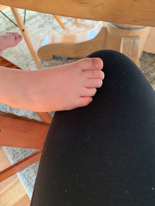Toddler showing affection to mom by touching her knee with his foot