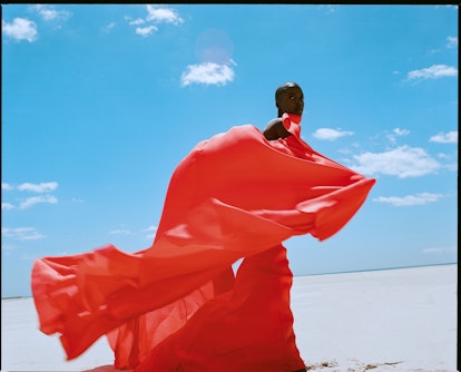 A model posing in an off-the-shoulder Carolina Herrera dress and walking