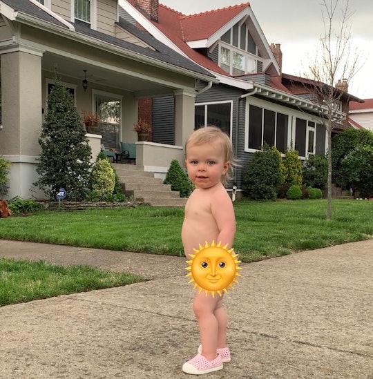 A toddler standing out on the street, while the sun emoji is covering their nakedness