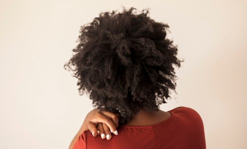A woman of color on an opioid treatment holding her shoulder because of the pain