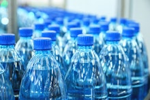 Plastic bottles of mineral water which contain microplastics going down a conveyer belt