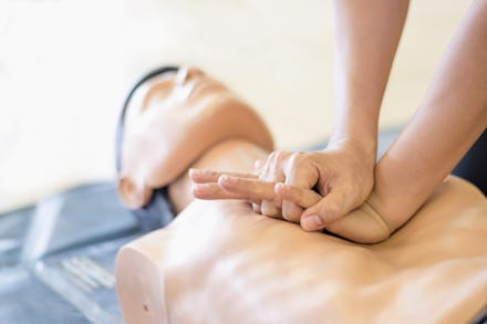 A person practicing CPR on a CPR doll