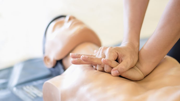 A person practicing CPR on a CPR doll