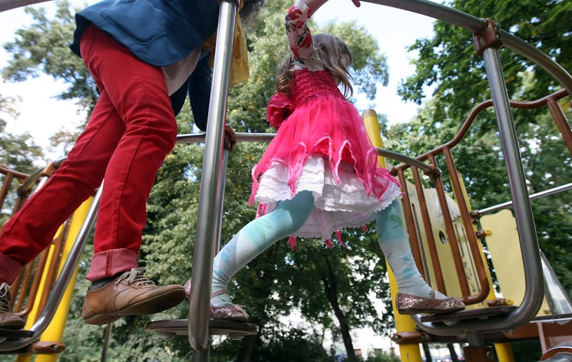 A daughter with her parent on a park climbing structure