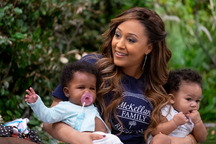 Tia Mowry walking and carrying her two kids