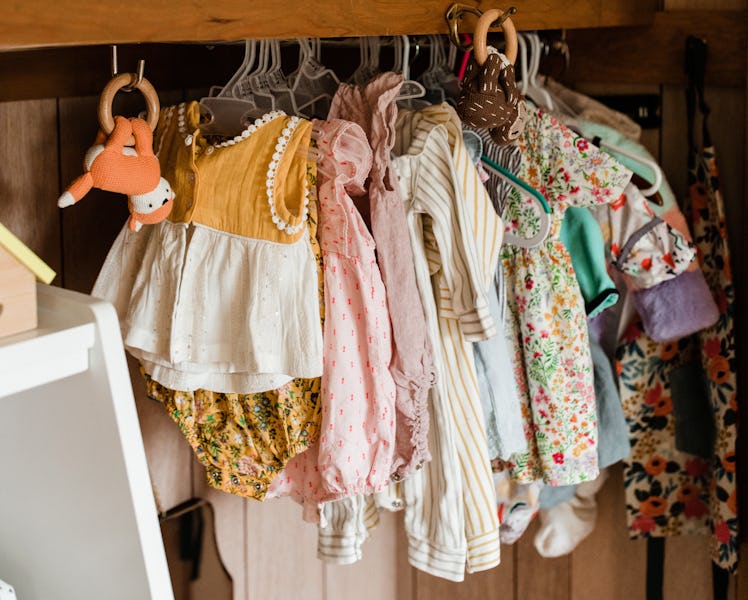 Molly Yeh's baby nursery with a variety of hand me down outfits hanging in the closet