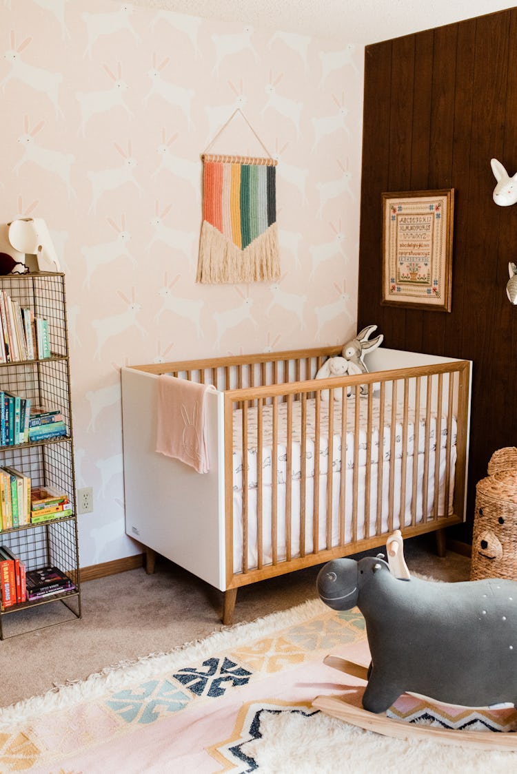 Molly Yeh's baby nursery with an embroidered ABC piece hanging above  the baby crib 
