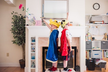 Six-year-old fraternal twins Logan and Jeremy dressed as kings standing in a living room