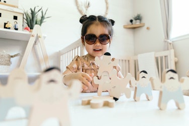 Joey wearing space buns and sunglasses playing in her room