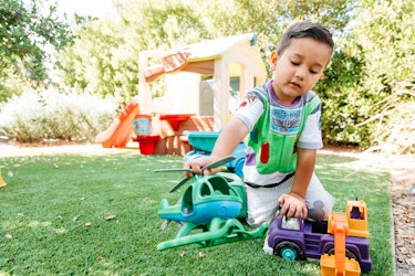 A 3-year-old Ferris playing with his toys in the garden