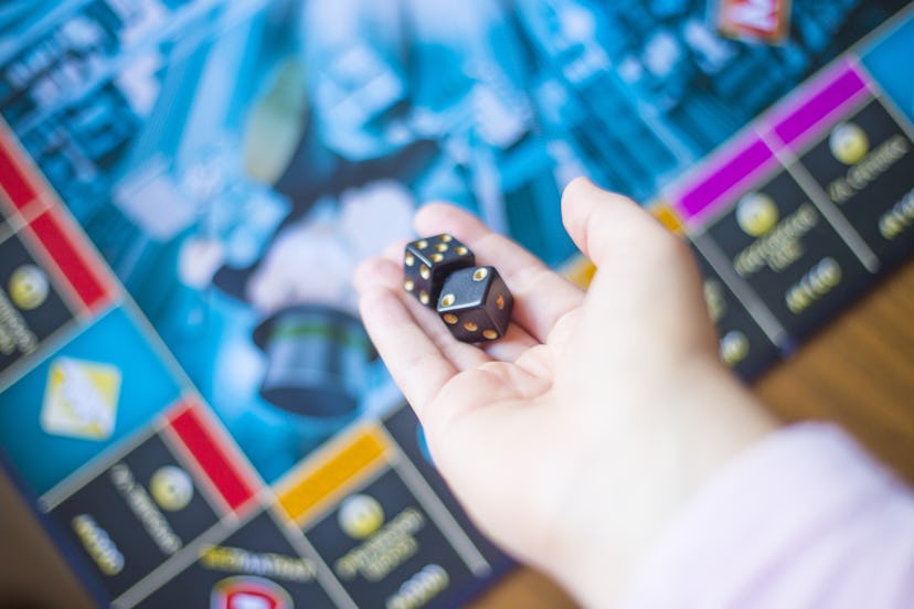 A hand throwing dice while playing a board game on the Fourth of July.