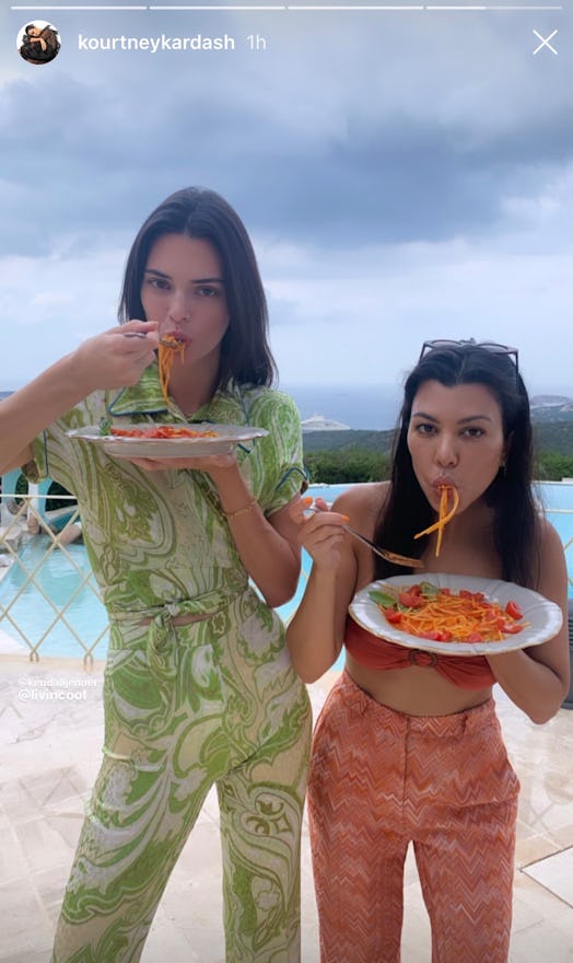 Kourtney Kardashian wearing her scarf top while eating spaghetti on an Instagram story with Kendal J...