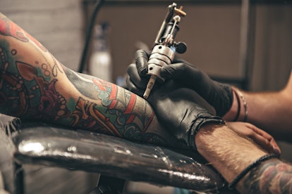 A tattoo addict getting tattooed all over his hand